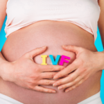 Donna incinta tiene le mani a forma di cuore sul pancione. Tra le mani, si trova la scritta IVF disegnata.